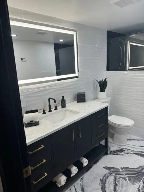 Completed dark vanity and tiled bathroom