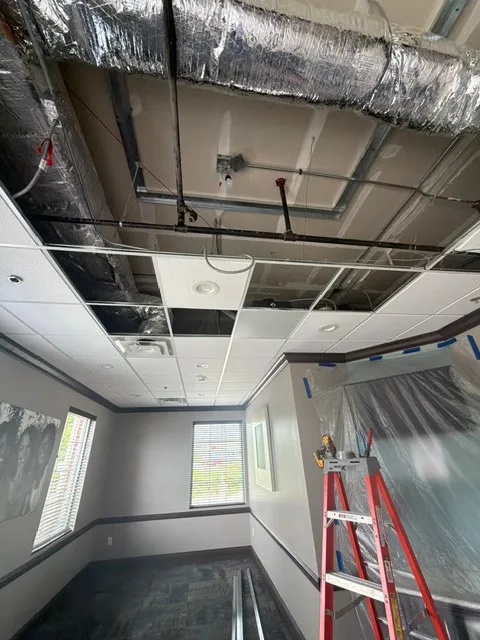 Open ceiling with visible framing and protected work area