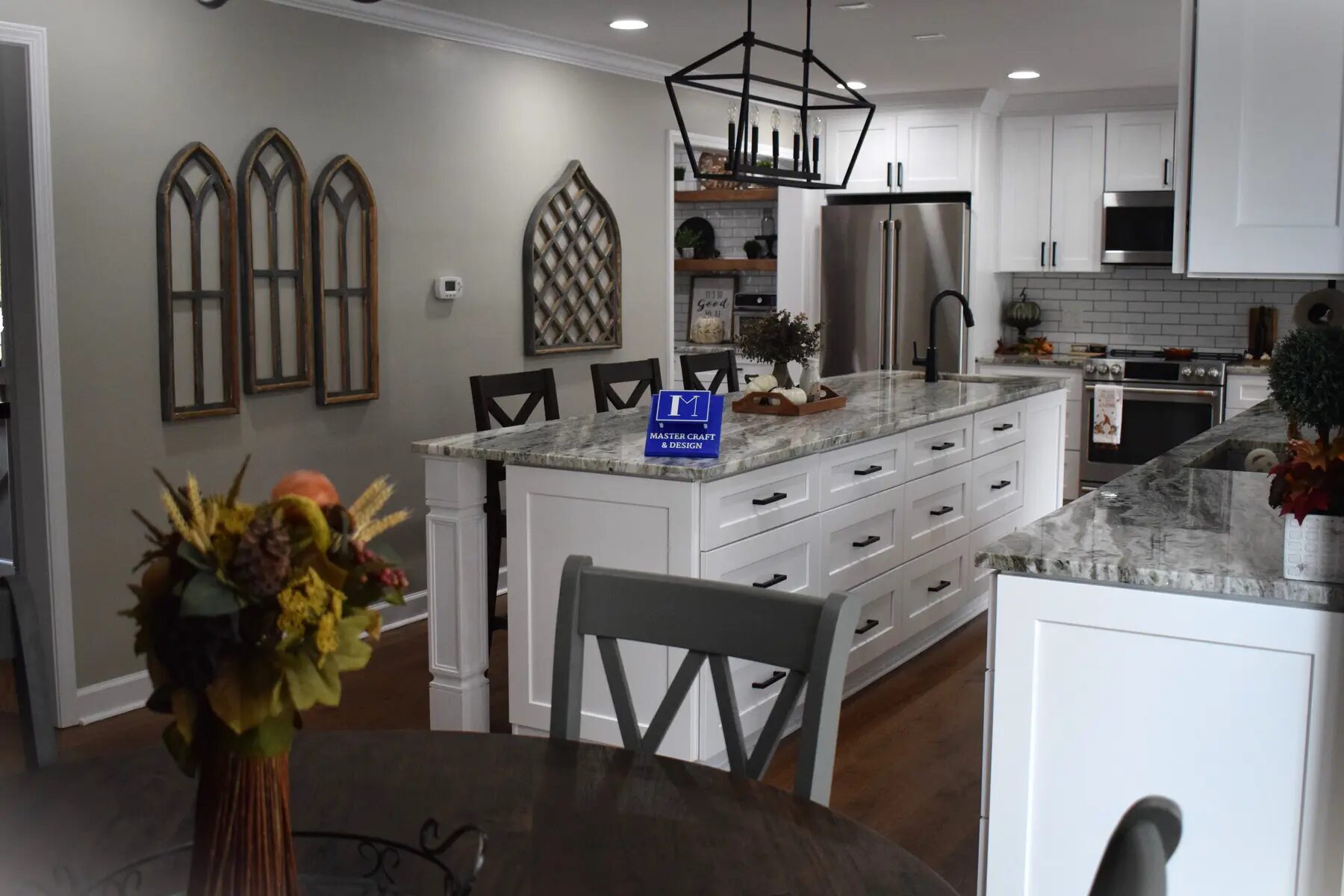 Detailed view of a white kitchen island, cabinetry, and pendant lights