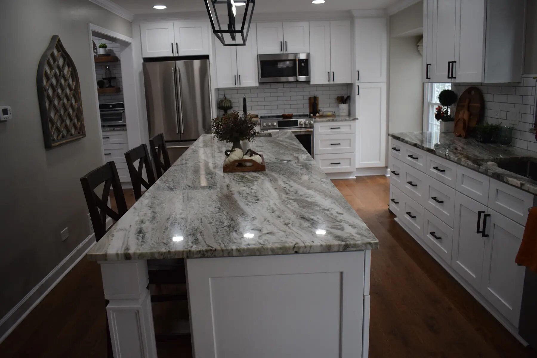 Wide completed kitchen with a long stone island and connected dining space