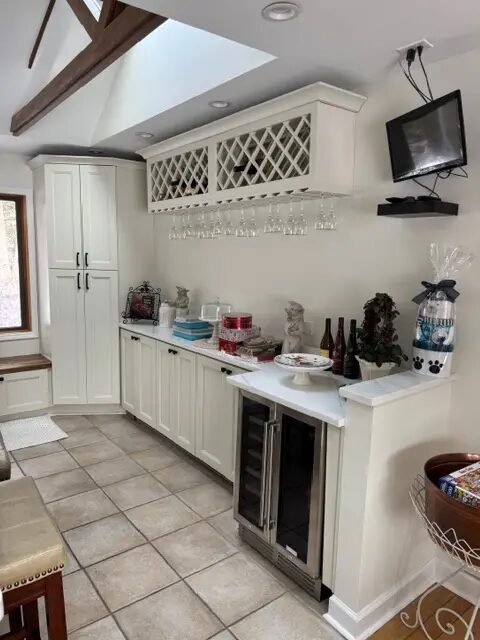 Custom white beverage cabinetry with bottle storage, counters, and under-counter appliances