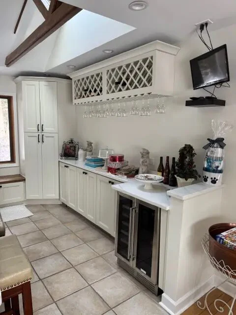 Custom white beverage cabinetry with bottle storage, counters, and under-counter appliances