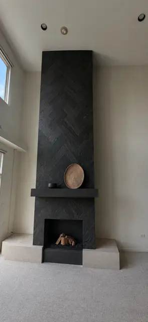 Completed modern black herringbone fireplace after remodeling