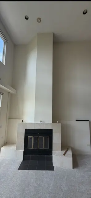 Original light tile fireplace before remodeling